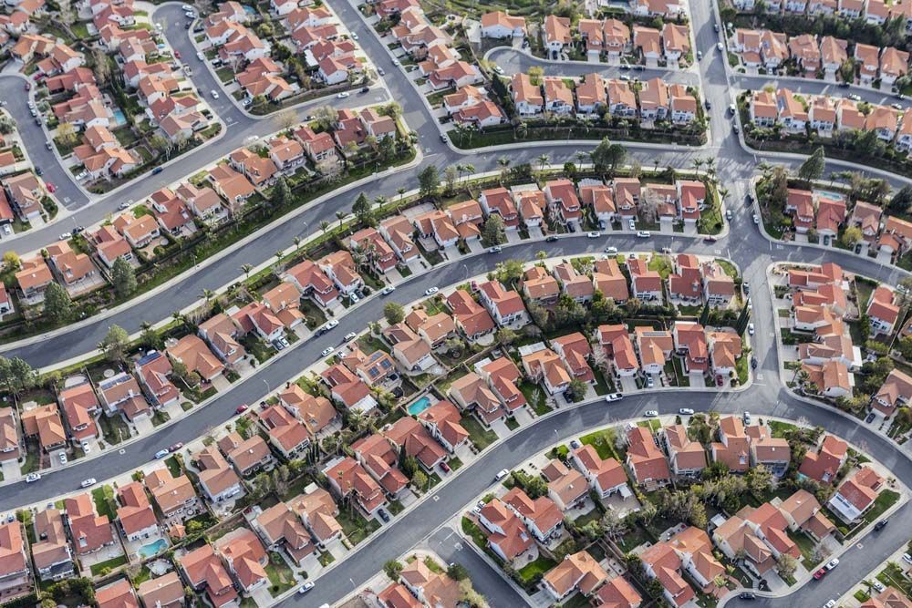 Aerial view of a suburban neighborhood with rows of houses and winding streets.