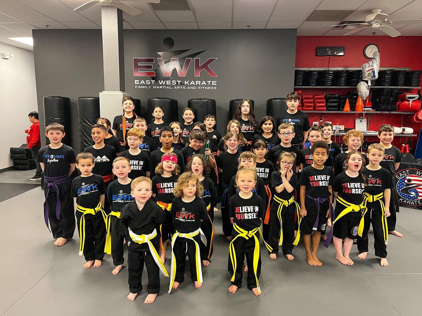 a group of kids are posing for a picture at east west karate