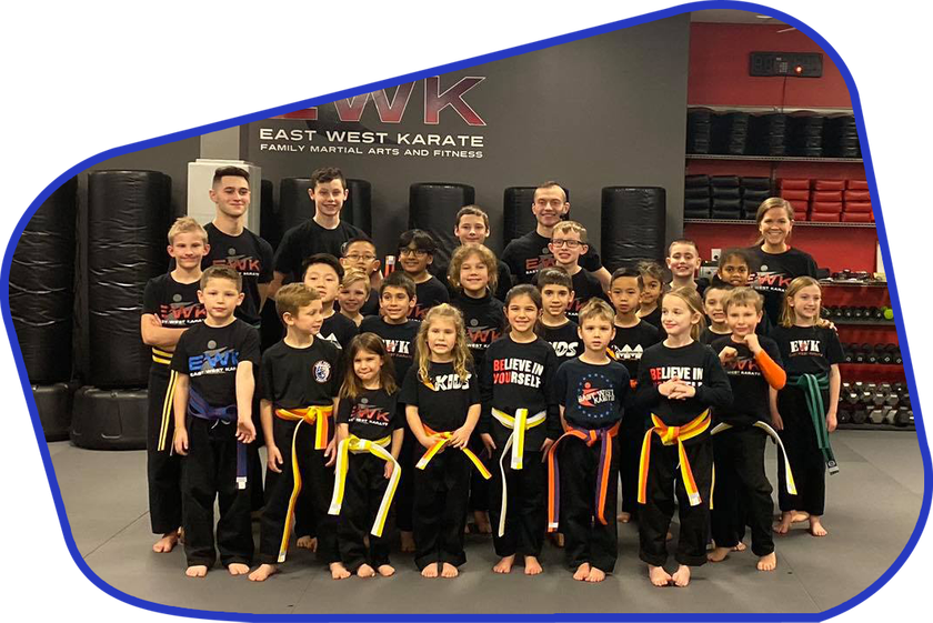 a group of kids are posing for a picture at east west karate