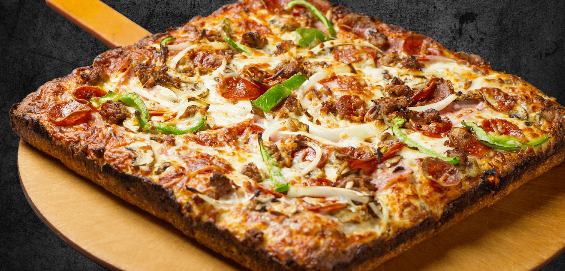 A pizza with pepperoni and cheese is sitting on a wooden cutting board Aubrees Pizza MI