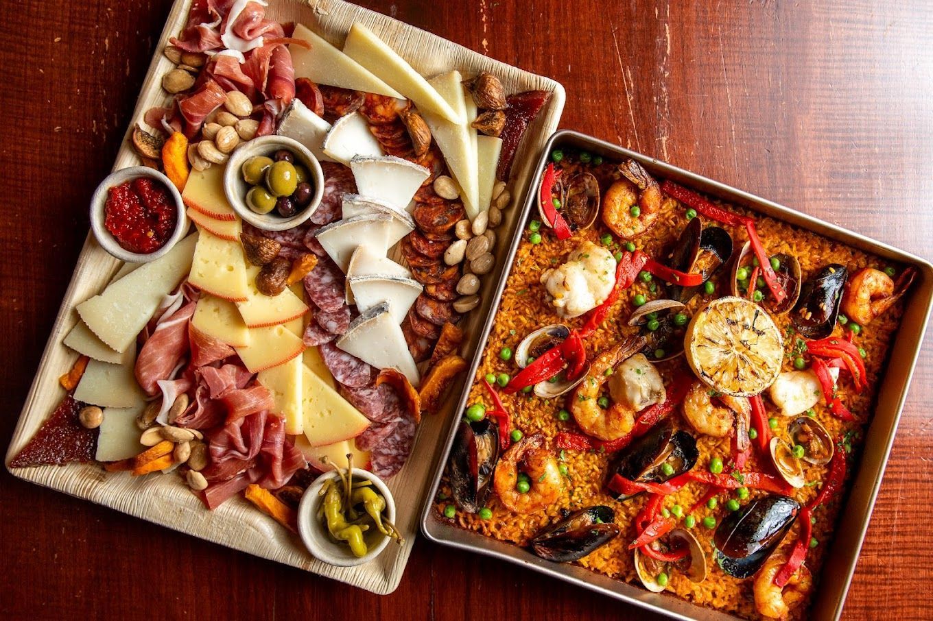 Two trays of food are sitting on a wooden table at Aventura Restaurant Ann Arbor