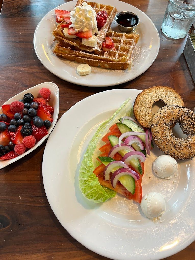 A table topped with plates of food and a bowl of fruit Cafe Zola Ann Arbor MI