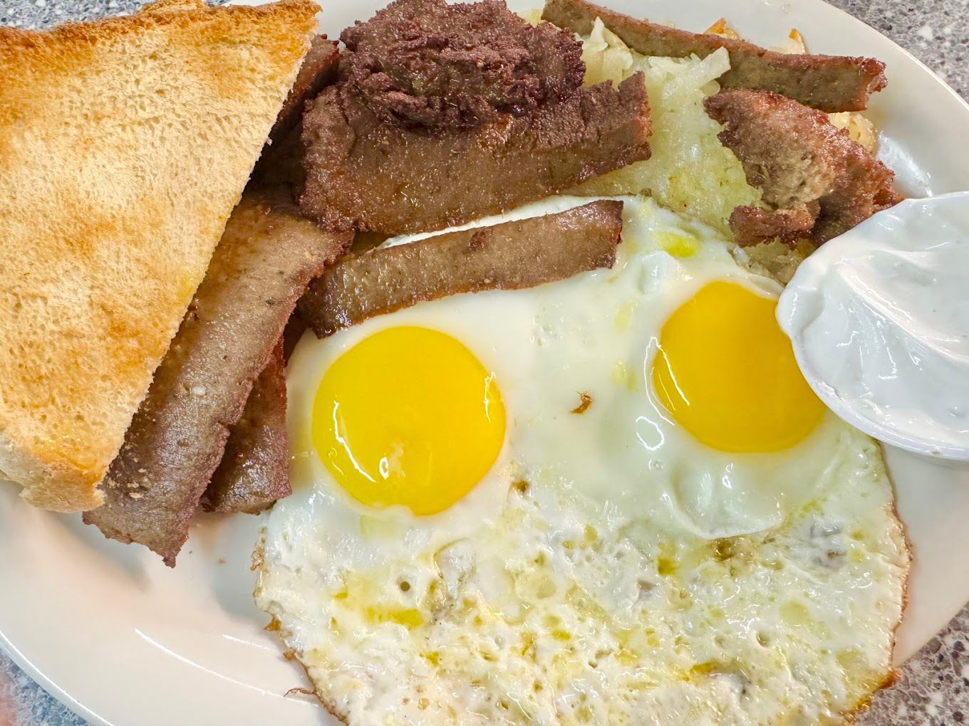 A white plate topped with eggs sausage and toast Fleetwood Diner Ann Arbor MI