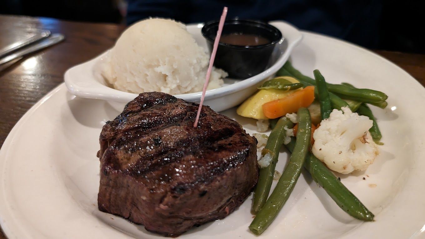 A white plate topped with a Filet steak mashed potatoes and green beans Knights Steakhouse Ann Arbor MI