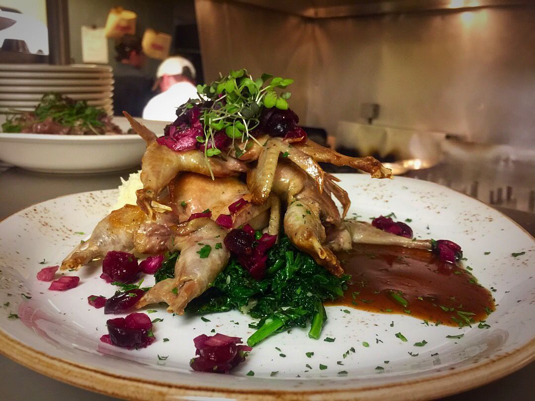 A close up of a plate of food with a chef in the background Paesano Restaurant Ann Arbor MI