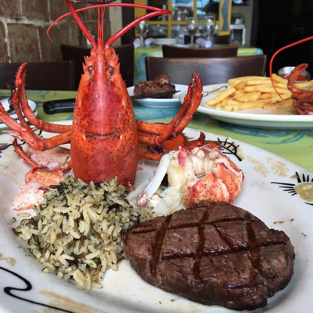 A plate of food with a lobster and a steak on it Real Seafood Company Ann Arbor MI