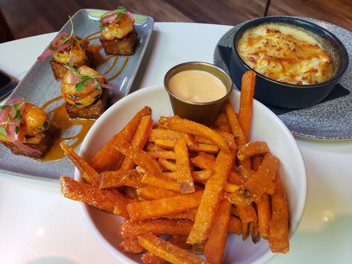A bowl of sweet potato fries sits on a table next to a bowl of macaroni and cheese Savas Restaurant Ann Arbor MI