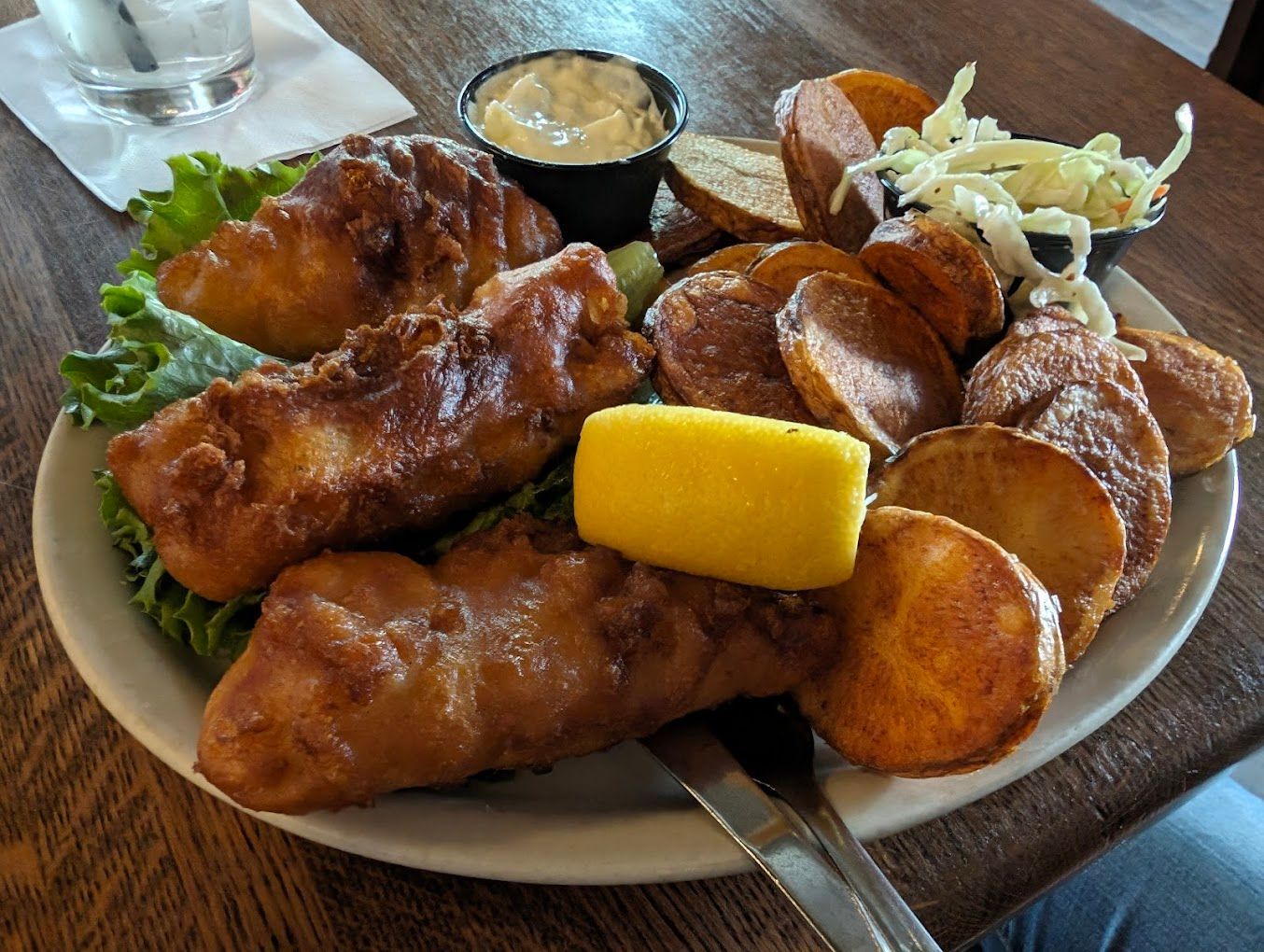 A plate of fish and chips with a lemon slice on top Sidetrack Bar & Grill Ypsilanti MI