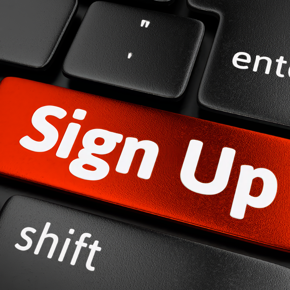 A red sign up button on a black keyboard to sign up for Smart Shopper 411