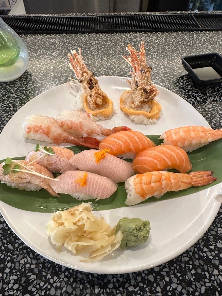 A white plate topped with sushi and shrimp on a table Slurping Turtle Ann Arbor MI
