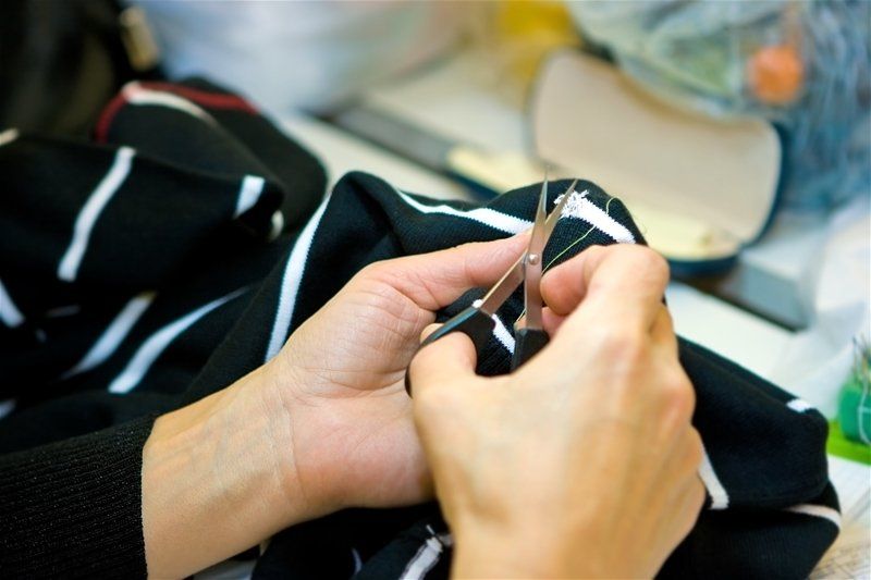 A person is cutting a piece of fabric with scissors