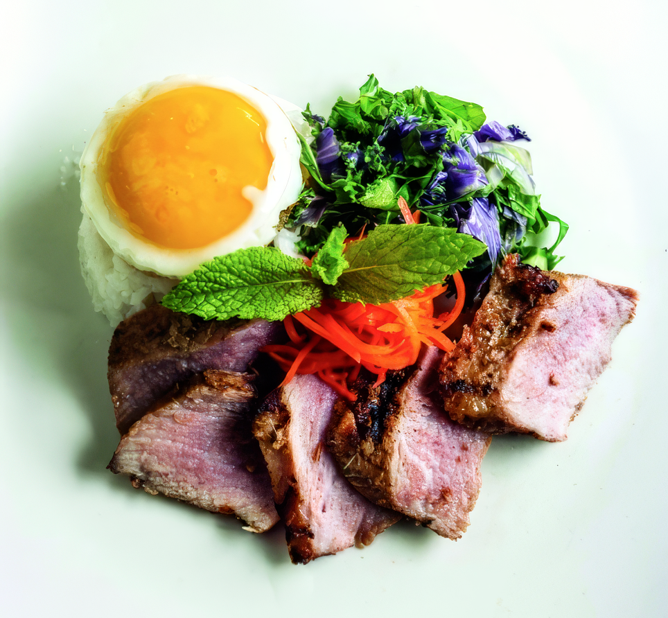 A white plate topped with meat eggs and vegetables The Taste Kitchen Ann Arbor