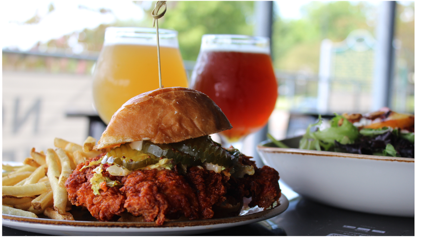 A fried chicken sandwich and french fries on a plate Thompson & CO Ypsilanti MI