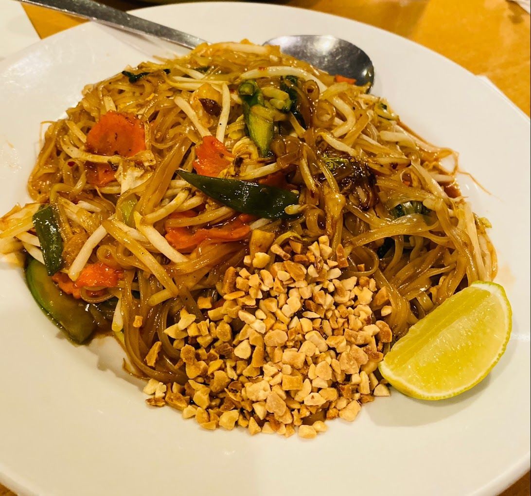 A white plate topped with noodles vegetables and peanuts Tuptim Thai Cuisine Ypsilanti MI