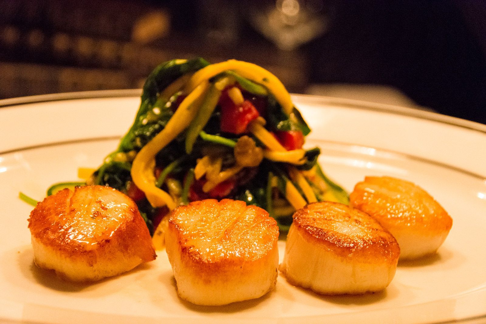 A plate of food with scallops and spinach on it Webers Restaurant Ann Arbor Michigan