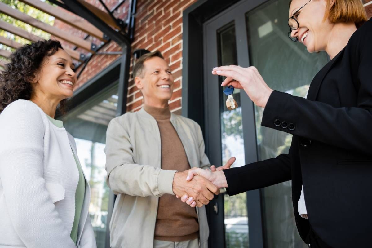 A realtor giving the keys to the owners of a new home in Indiana at HomeServices Real Estate Academy near Lexington, KY