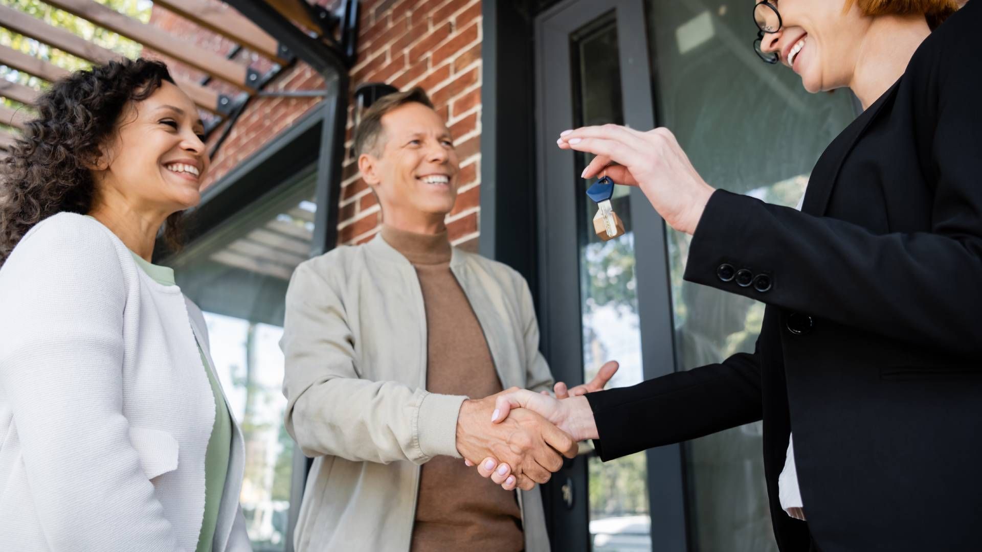 A realtor giving the keys to the owners of a new home in Indiana at HomeServices Real Estate Academy