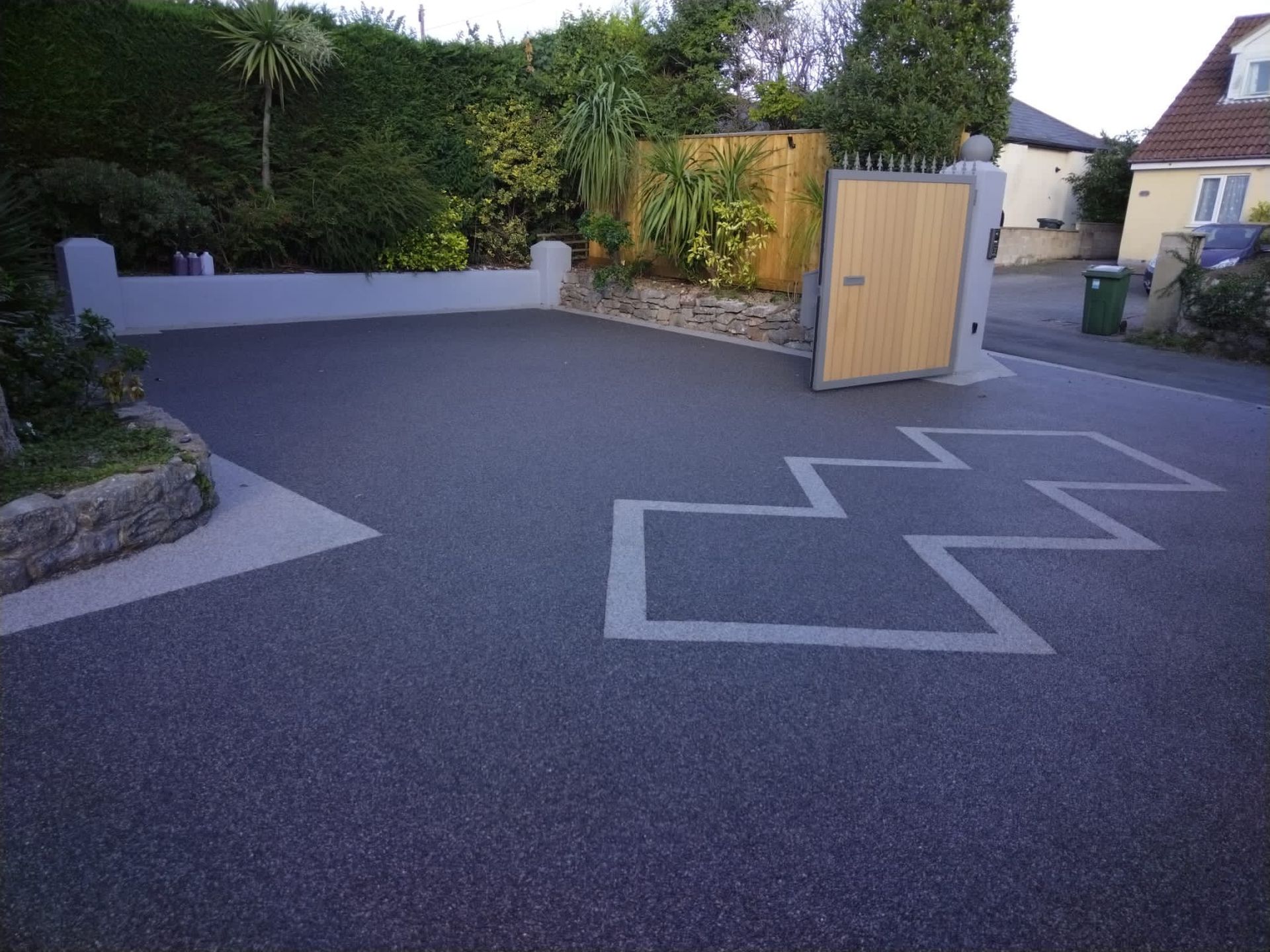 Black resin driveway with a grey pattern and border.