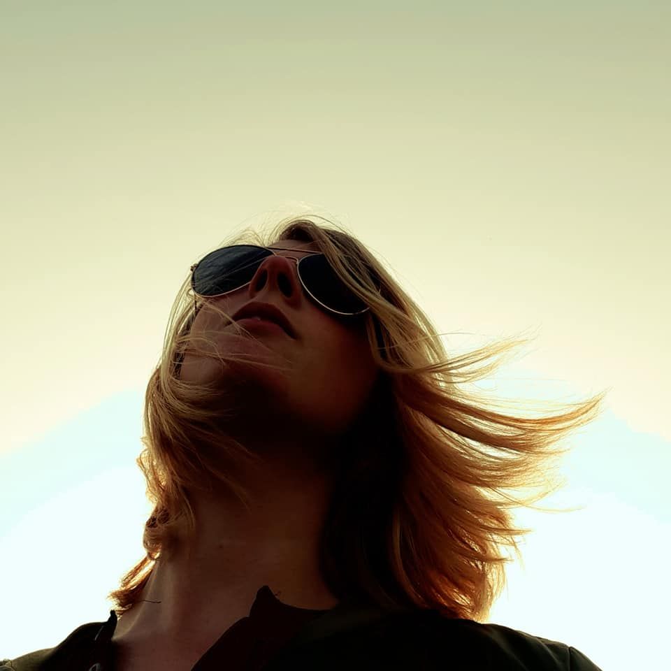 Een vrouw in een groen shirt lacht met open mond