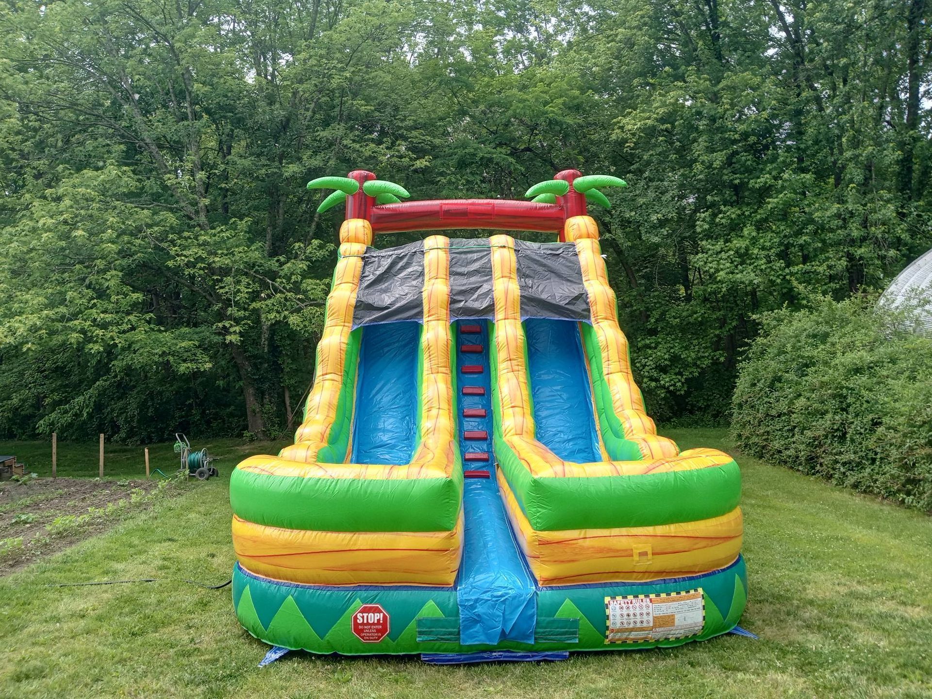 A large inflatable water slide is sitting on top of a lush green field.