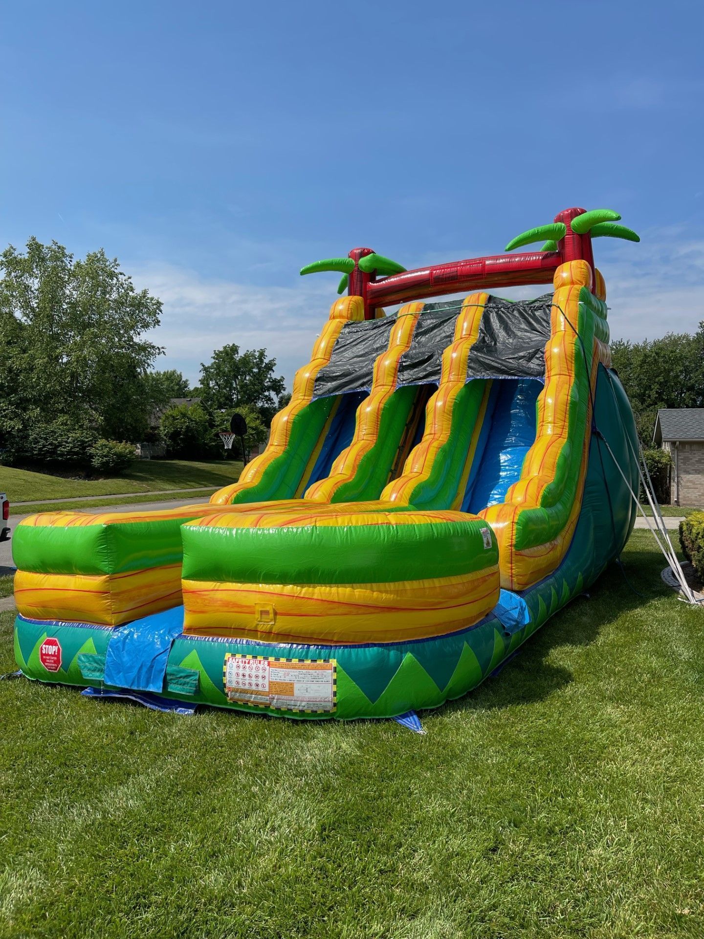 A large inflatable water slide is sitting on top of a lush green field.