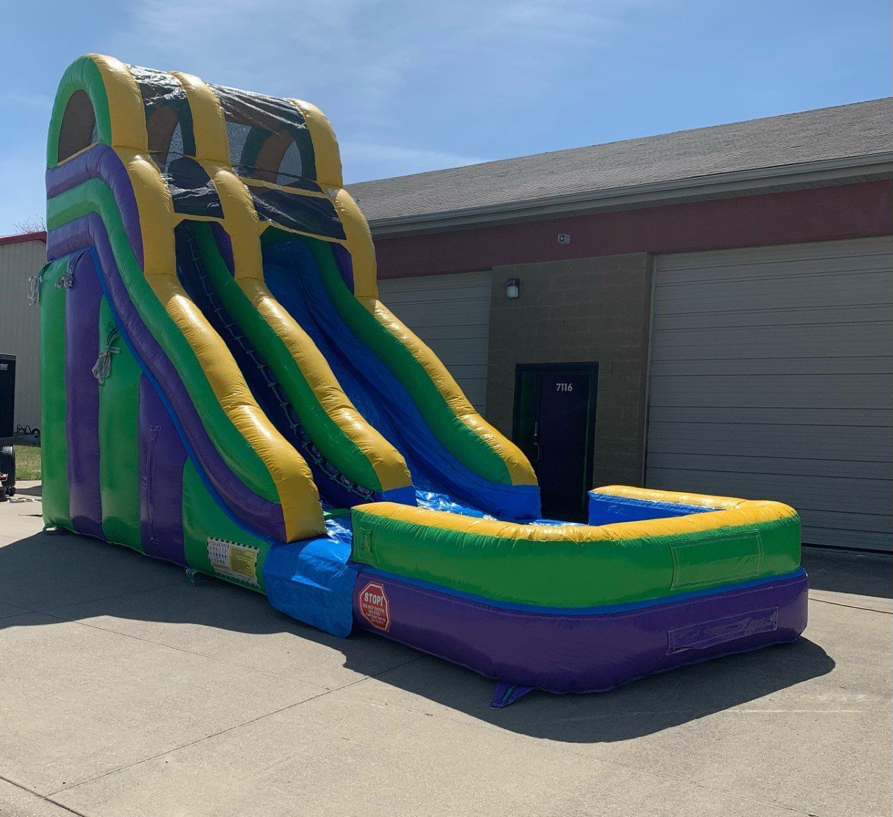 An inflatable water slide is sitting in front of a building.