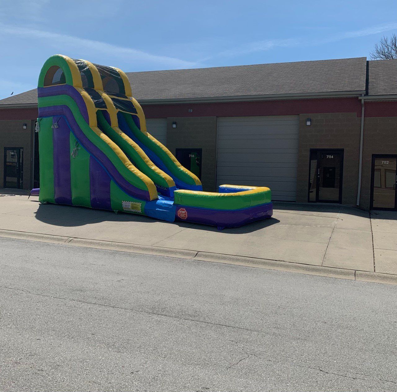 An inflatable water slide is in front of a building