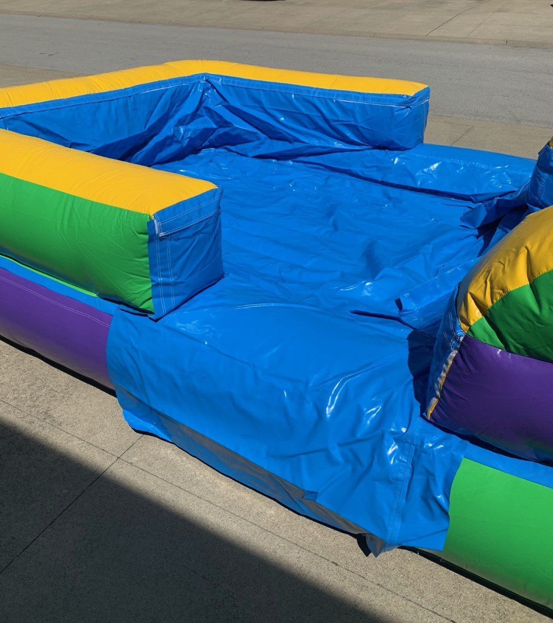 A blue inflatable couch with yellow green and purple cushions