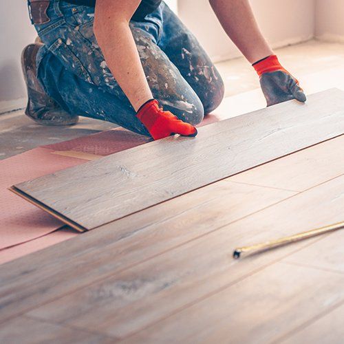 Worker Professionally Installs Floor Boards — Detroit, MI — Captivation Craft