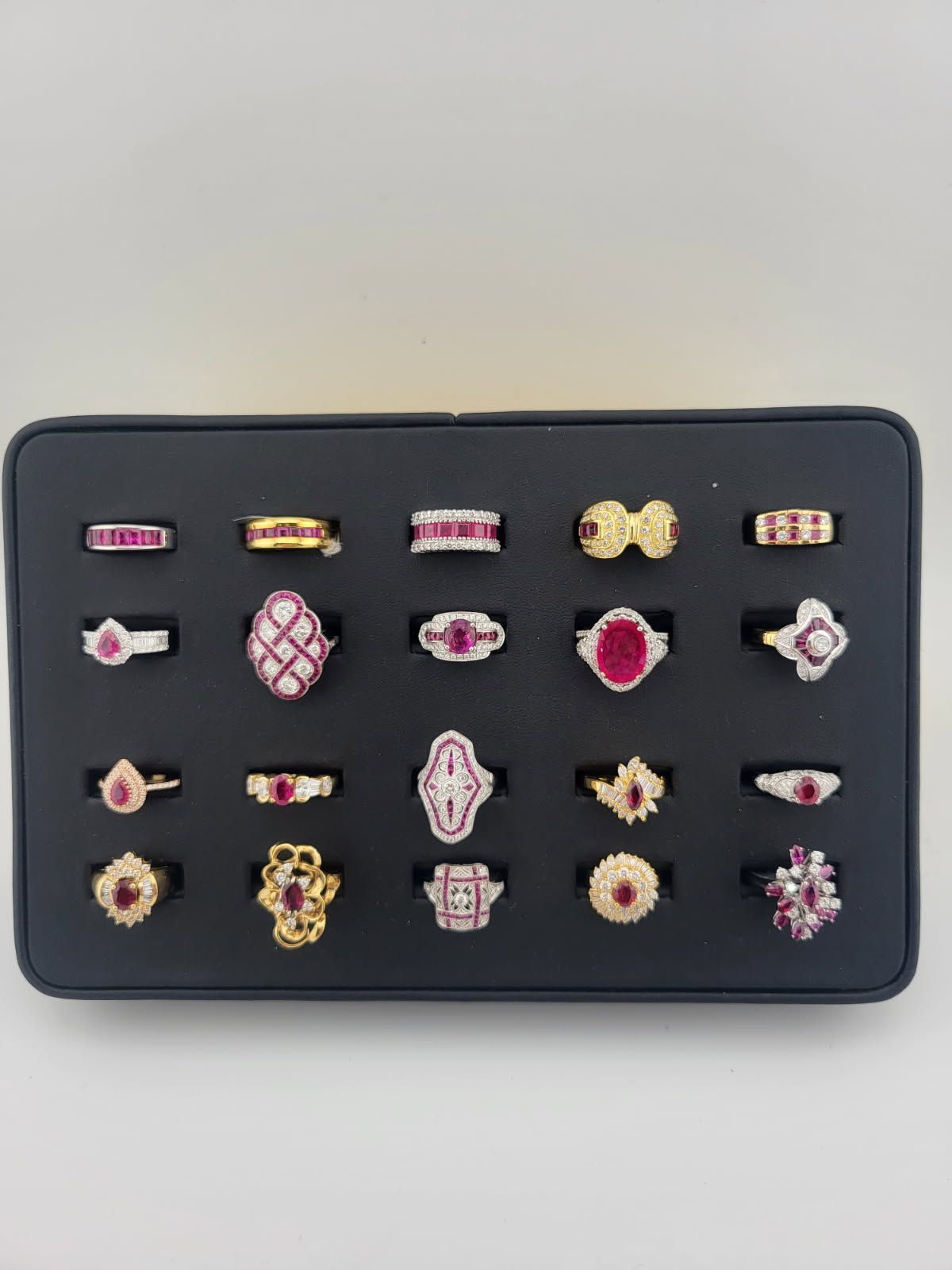 A tray displaying a collection of ruby and diamond rings in various gold settings.