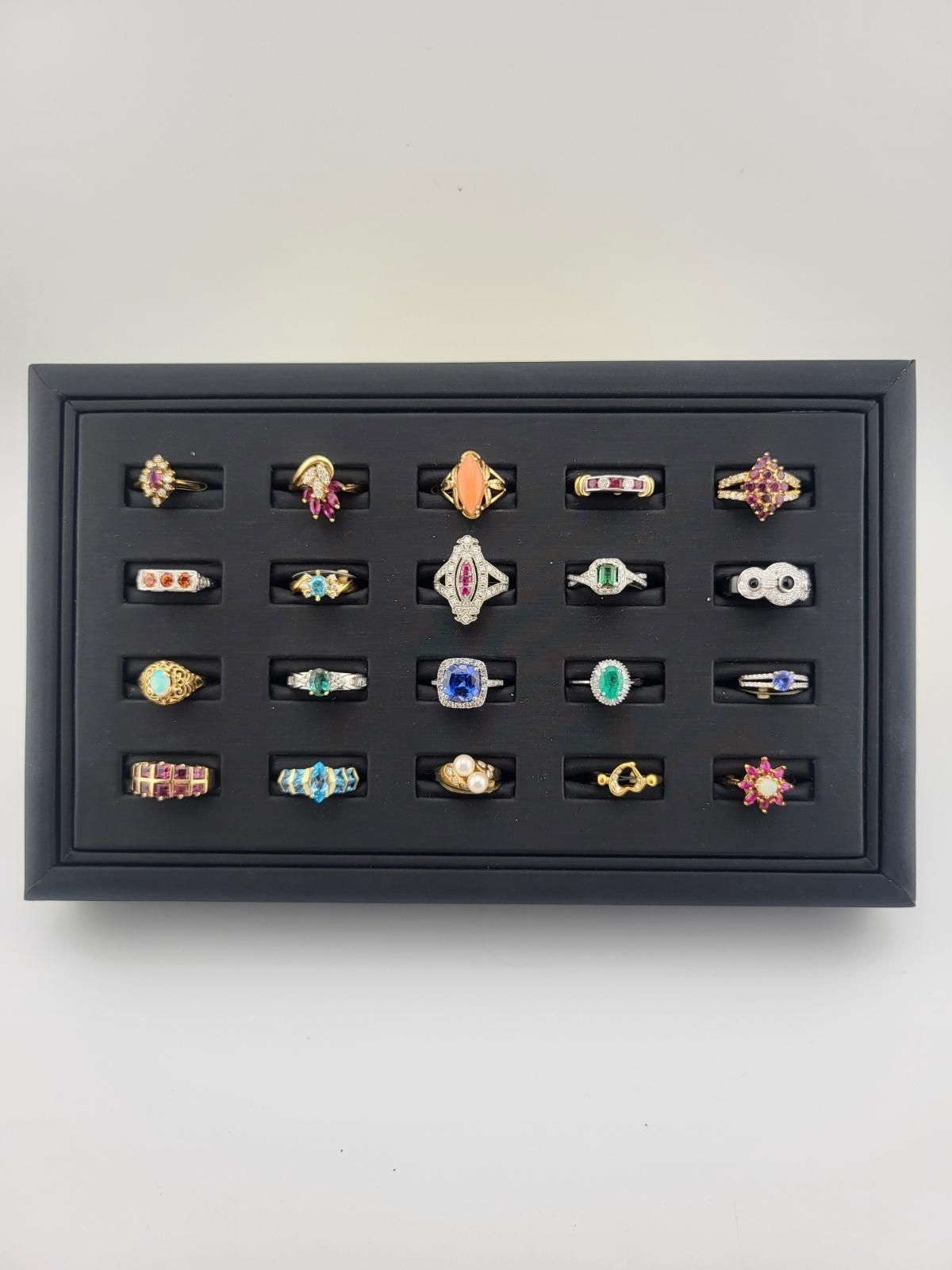 Black display case with a collection of colorful rings.