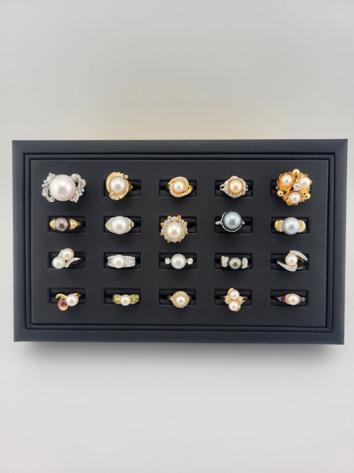Black display case with twenty pearl rings.