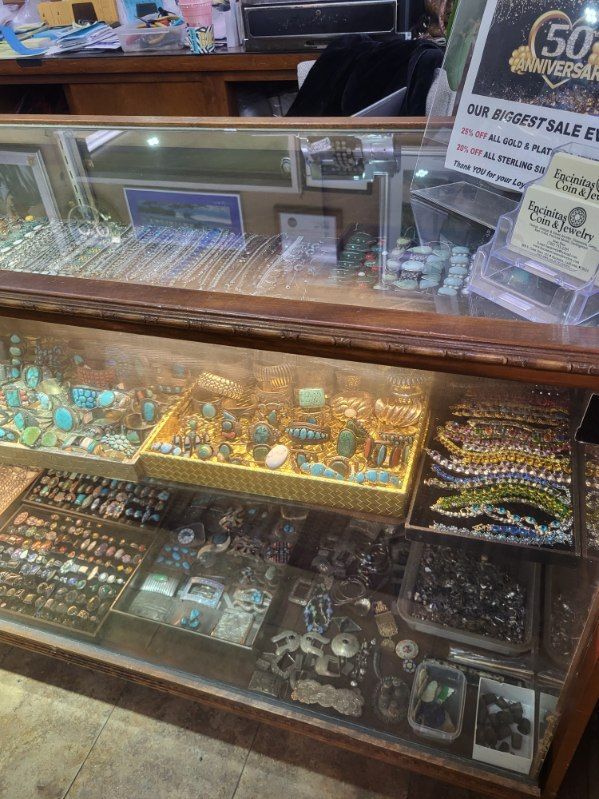 Jewelry display case with rings, necklaces, and turquoise stones.