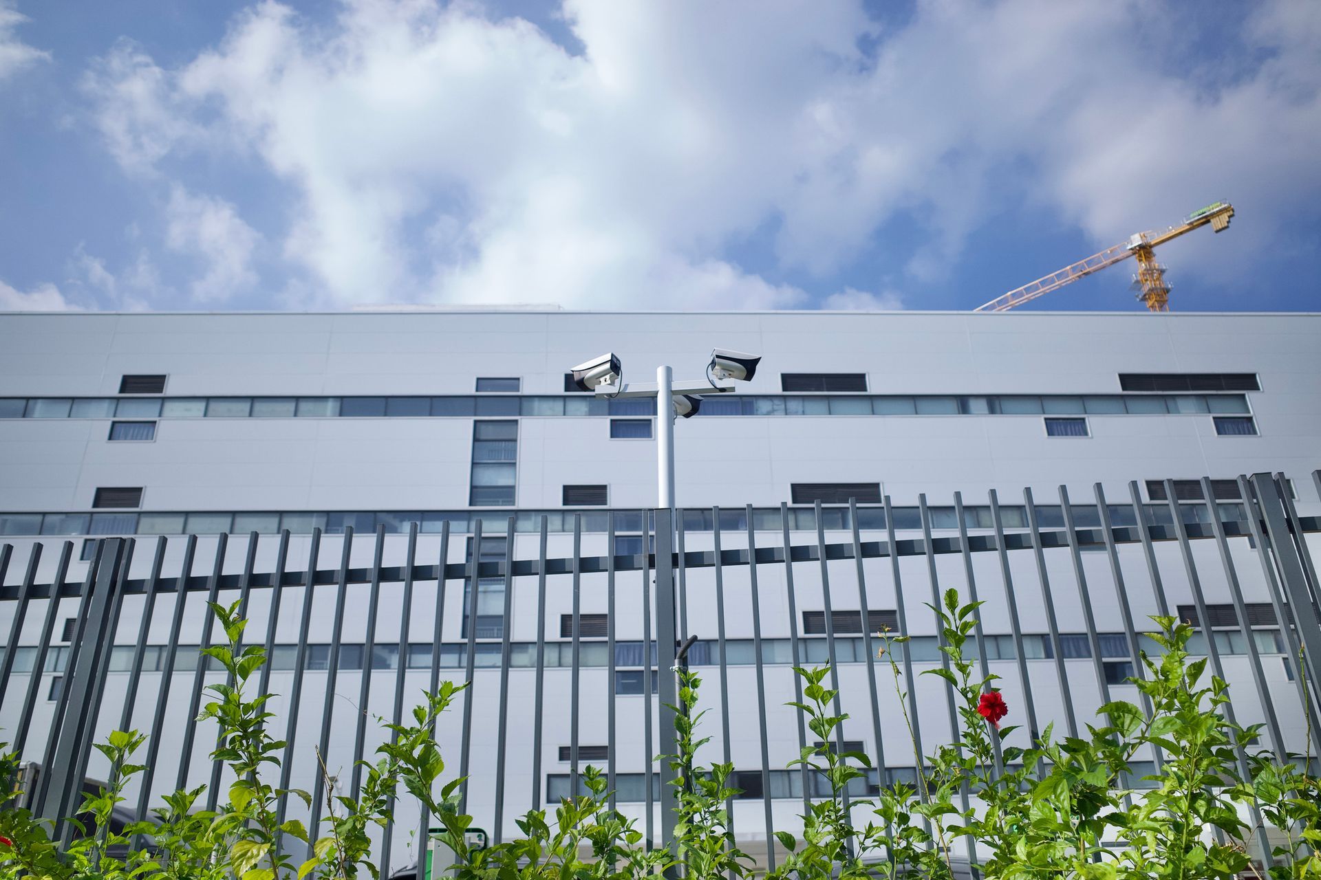 A modern building under the surveillance of a camera in the railing.