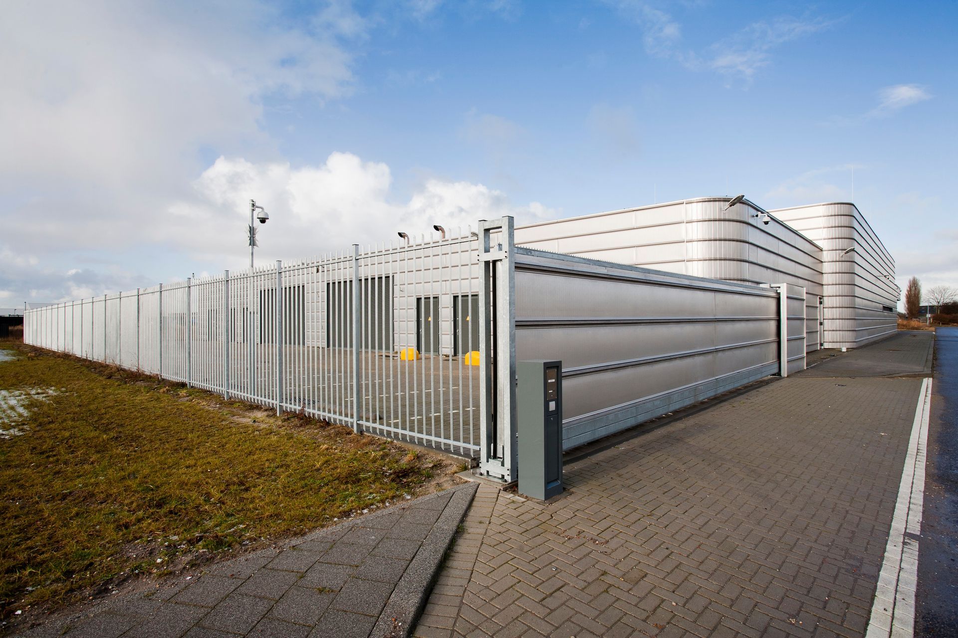 Well-secured, metal industrial building, with metal fencing, installed by fence contractors.