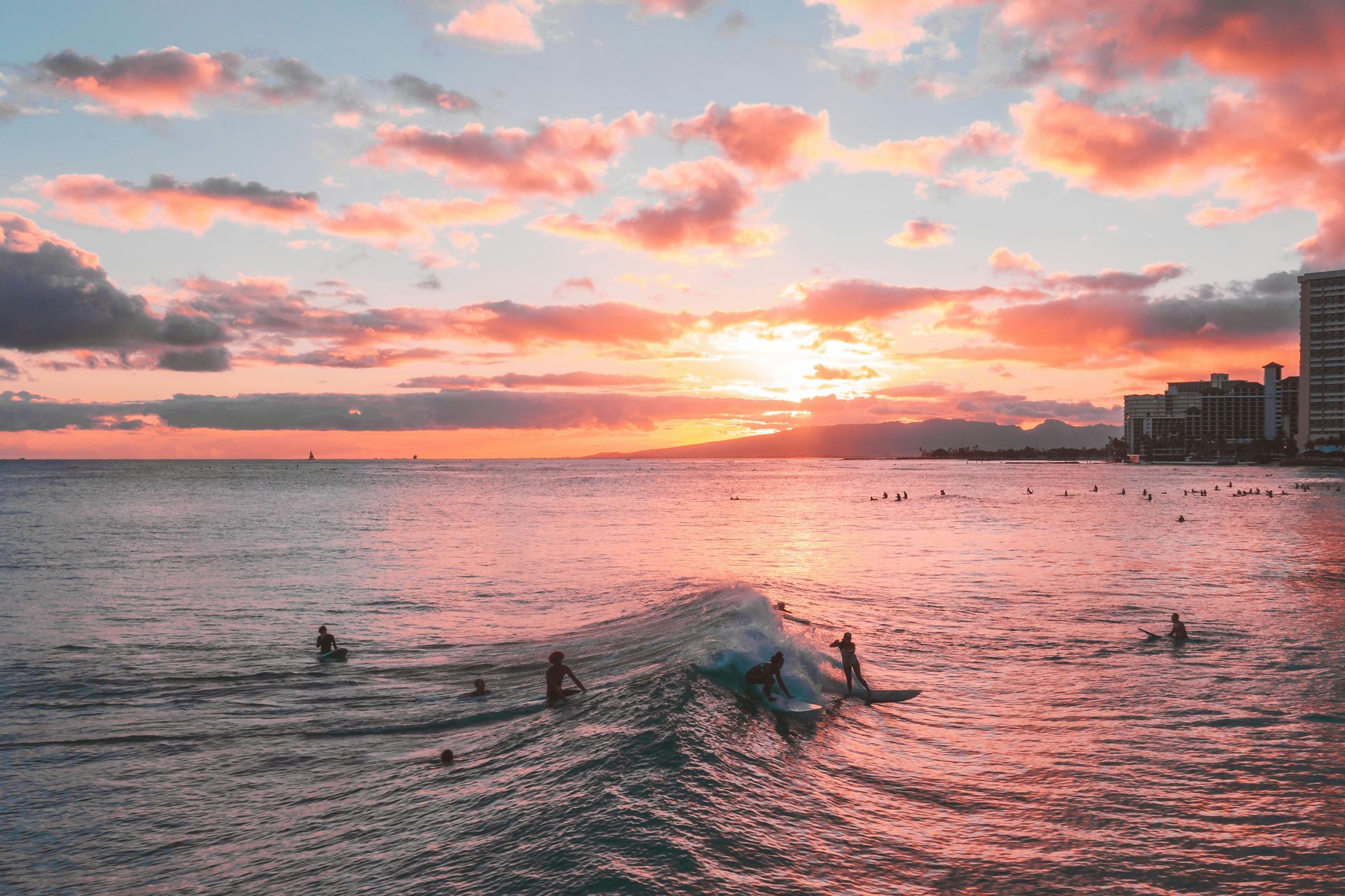 Surfers in Hawaii at sunset