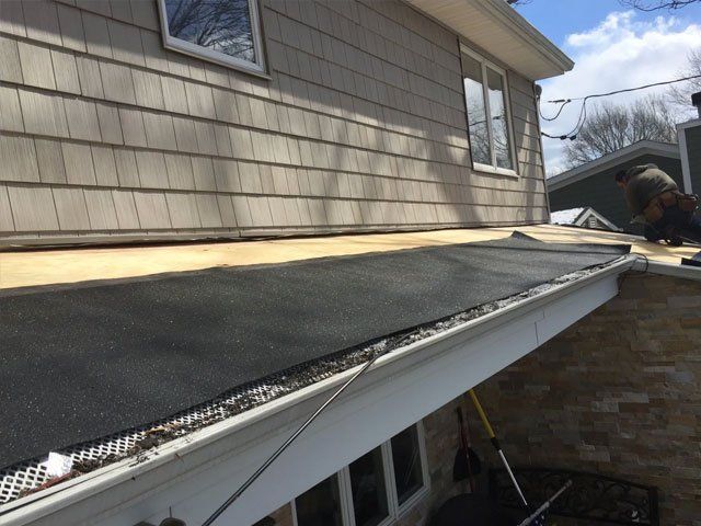 A man is working on the roof of a house.