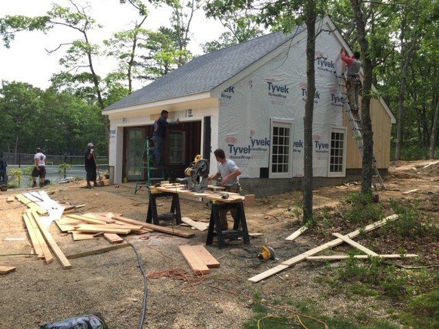 A group of people are working on a house that is being built.
