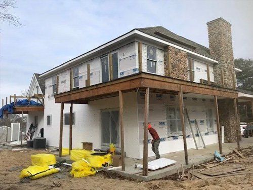 A man is working on the side of a house under construction.