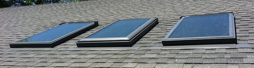 Three skylights are sitting on top of a roof.