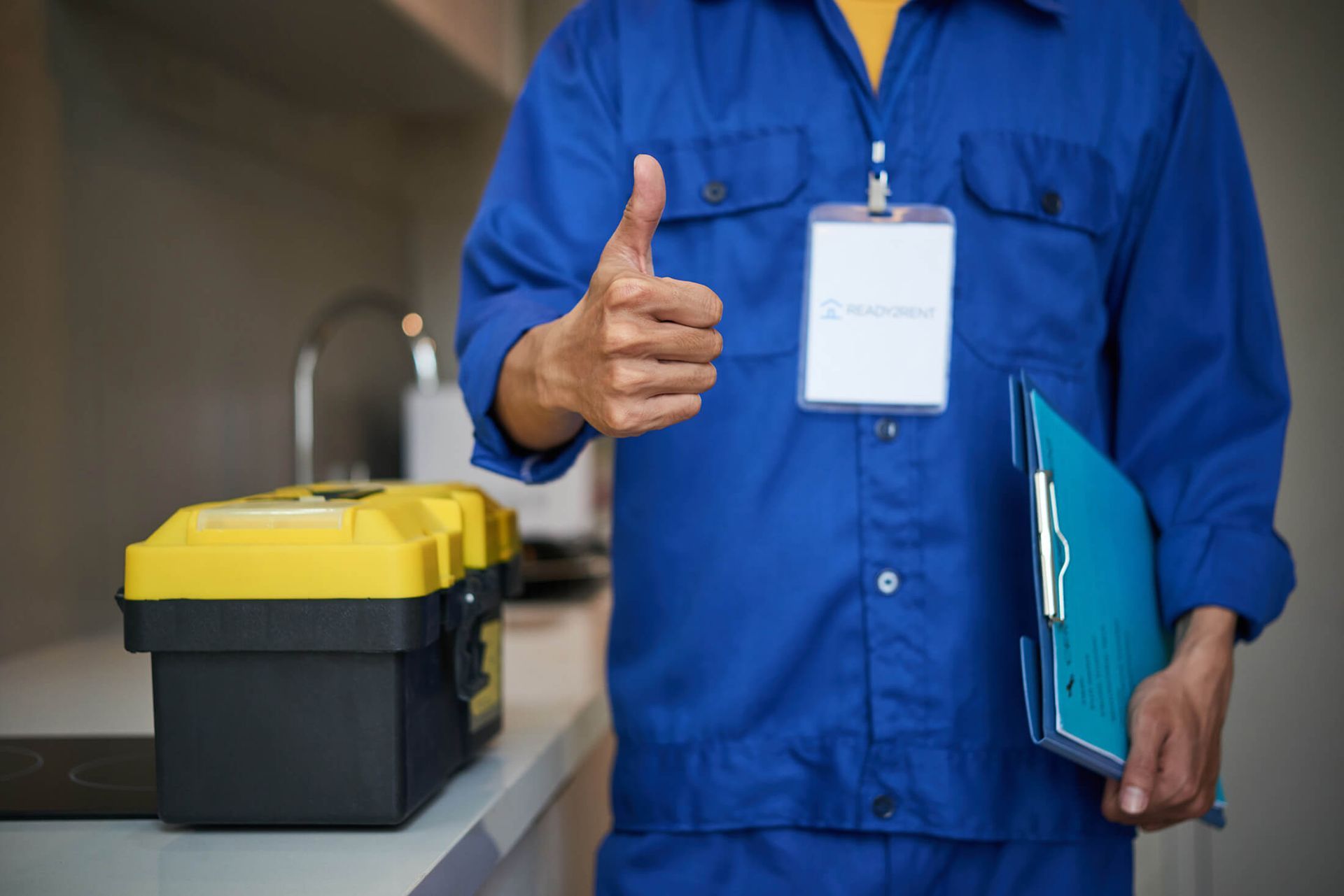 Un hombre con uniforme azul levanta el pulgar.