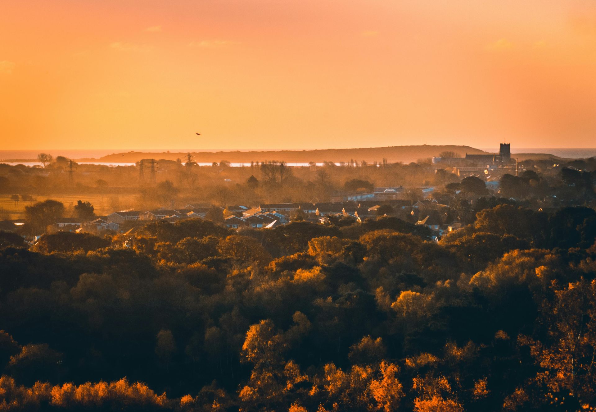 Orange sky at sunset, over a town.