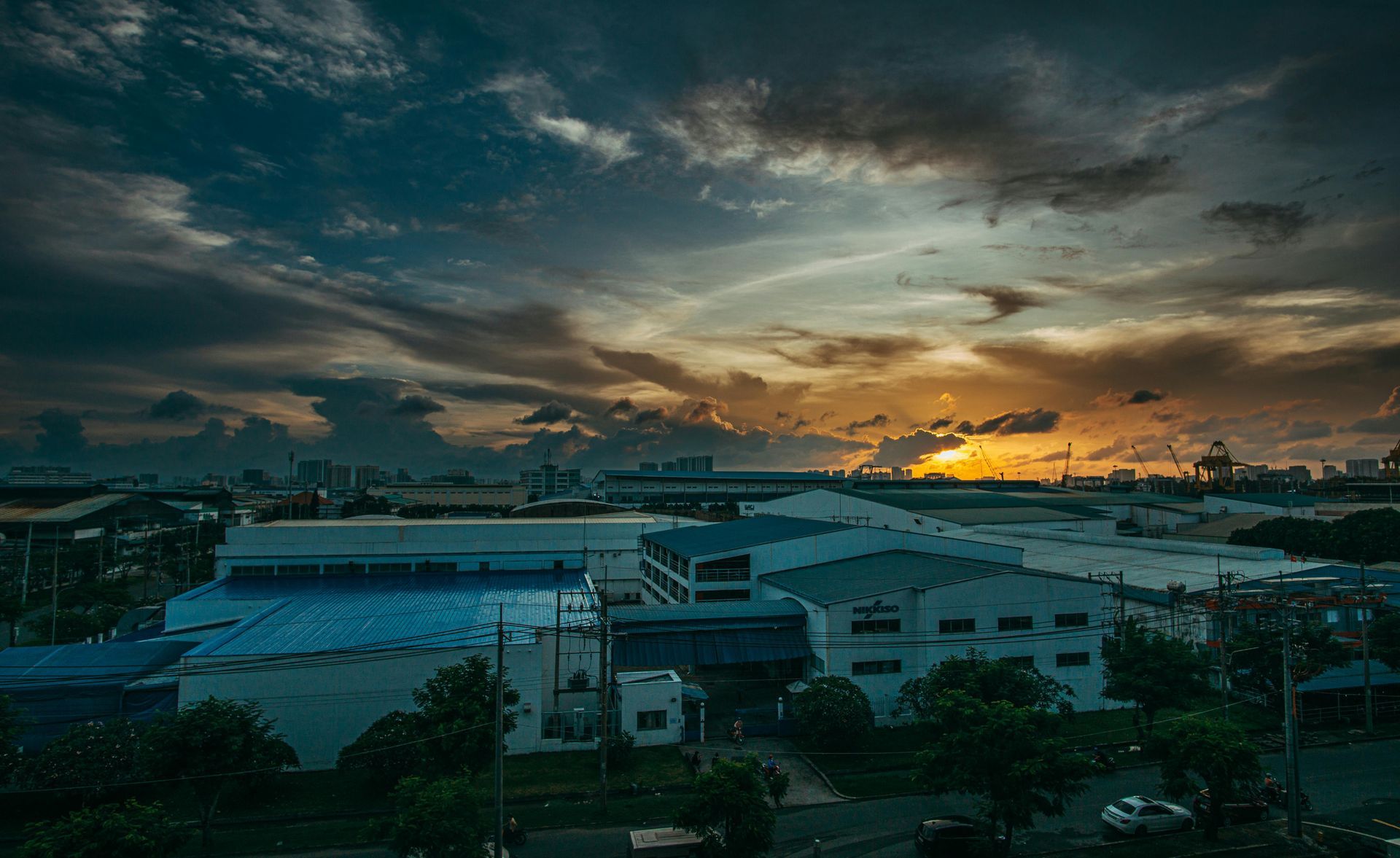 Warehouses against cloudy sky at sunset