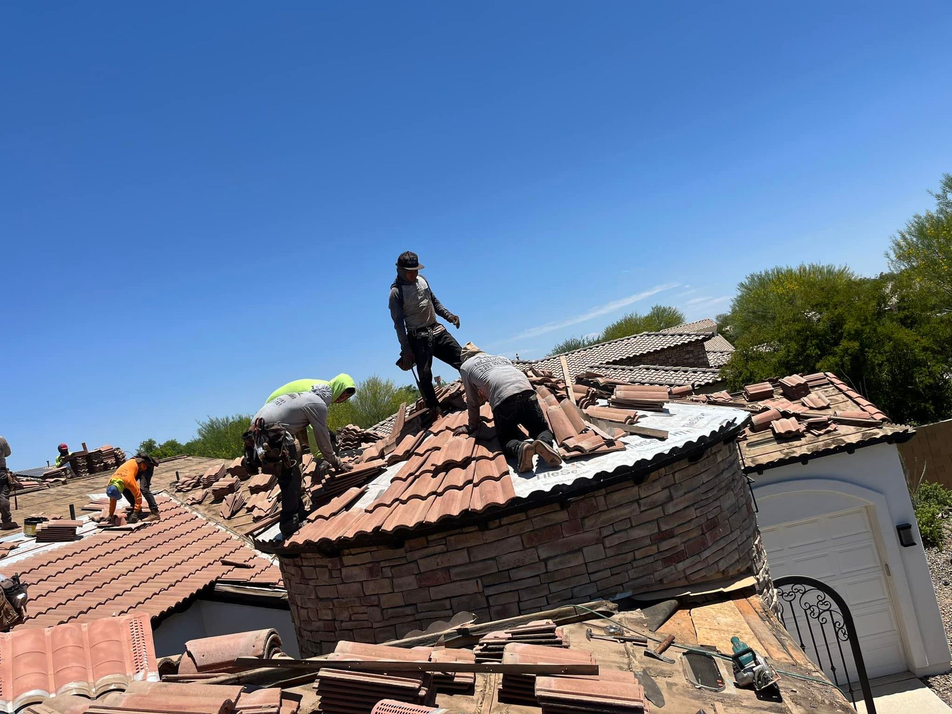 A group of people are working on the roof of a house.
