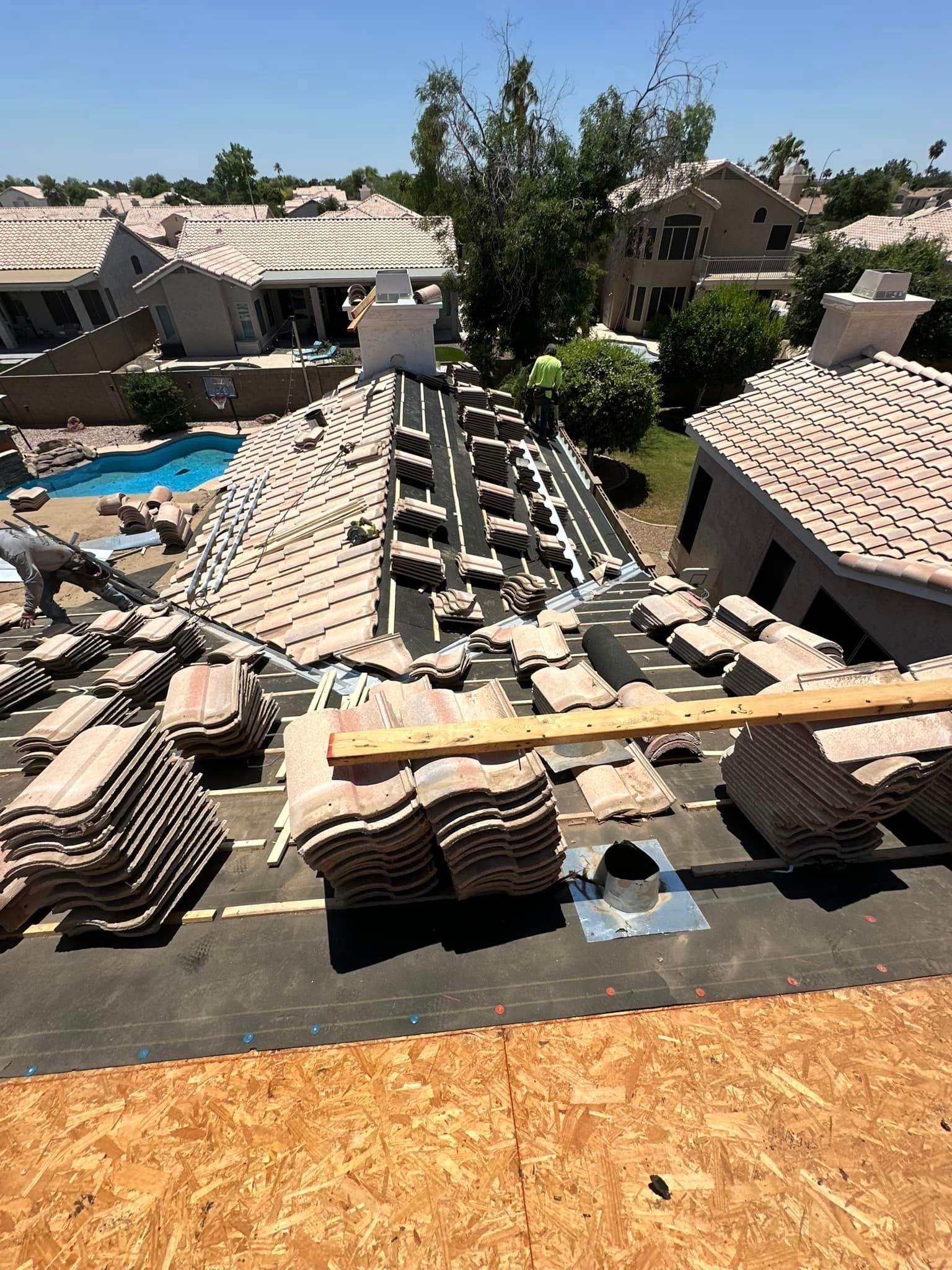 A roof with a lot of tiles on it and a pool in the background.