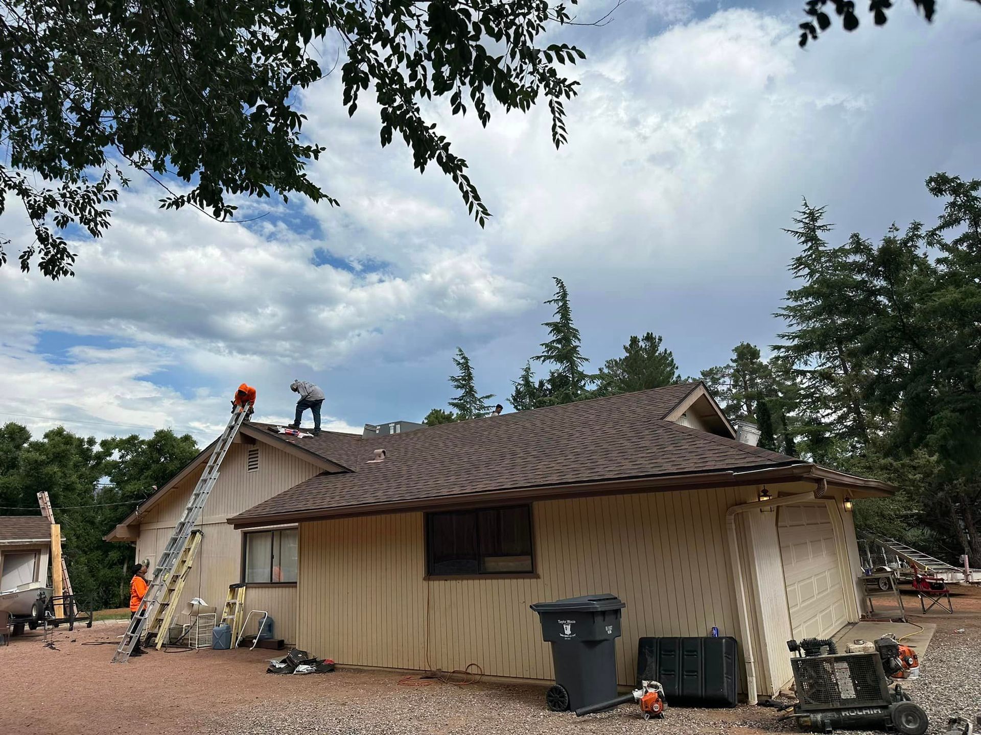 A group of people are working on the roof of a house.