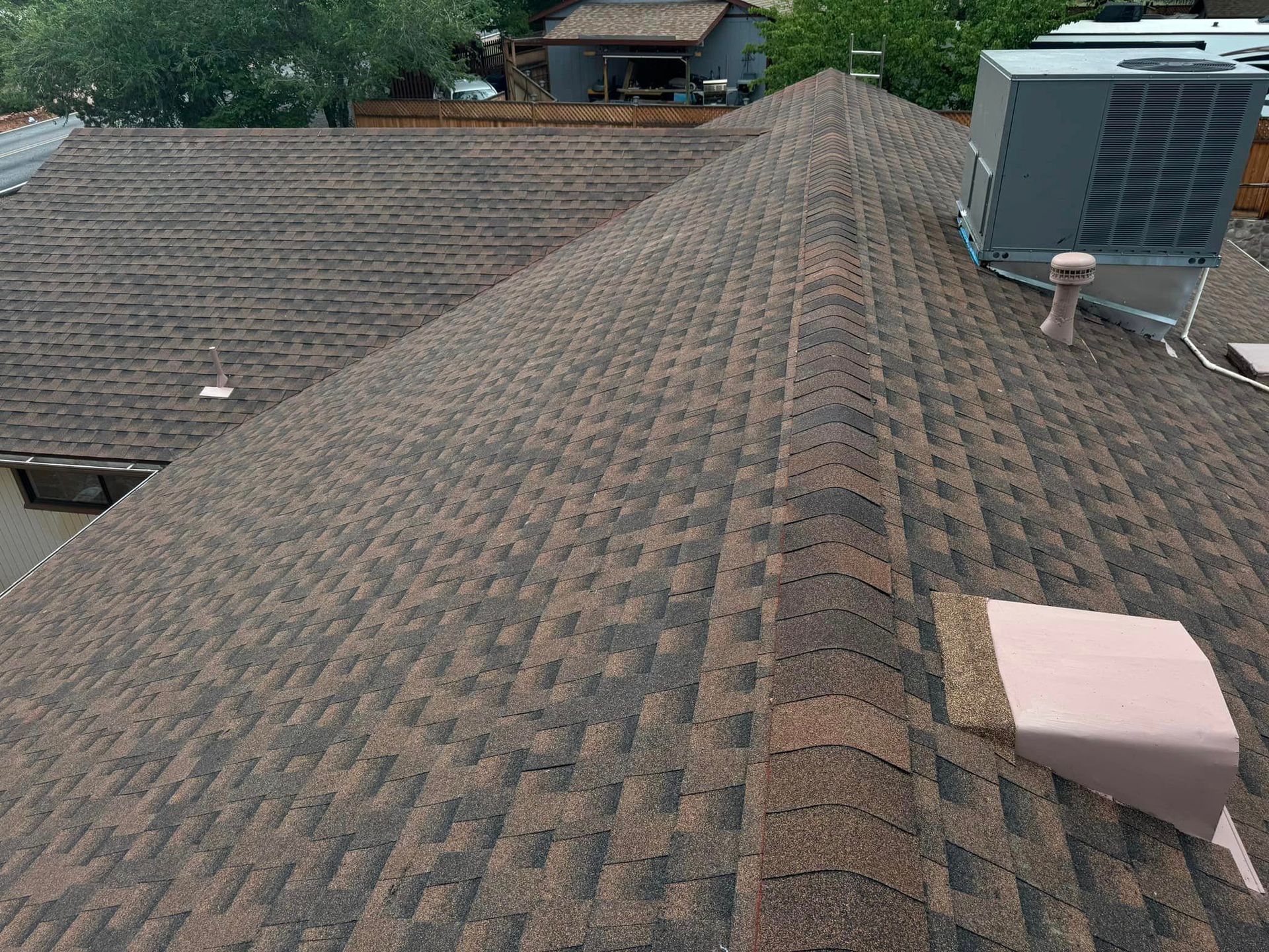 A close up of a roof with a air conditioner on top of it.