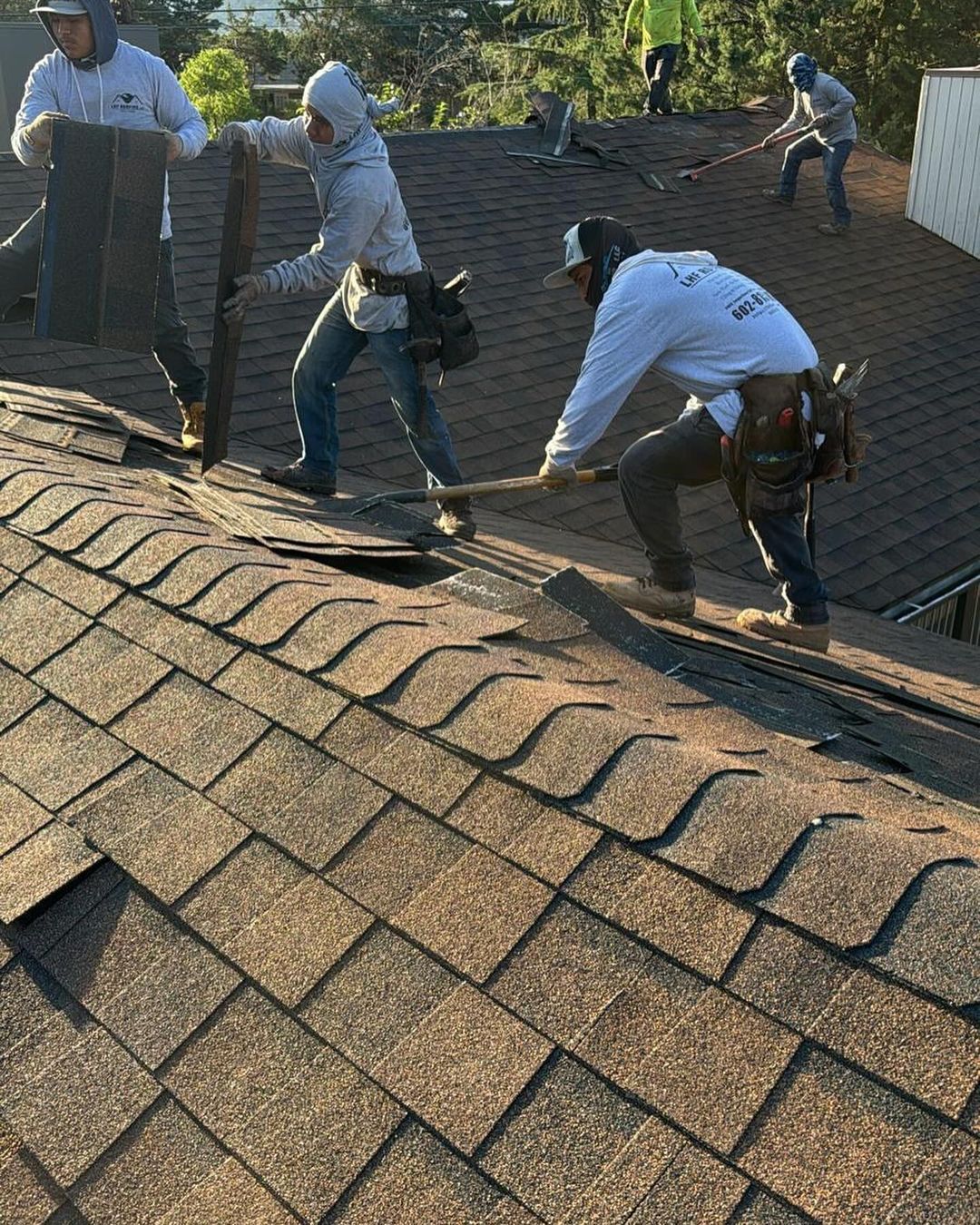 A group of men are working on a roof.