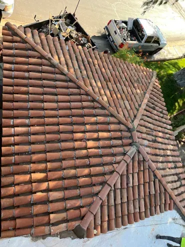 An aerial view of a tiled roof with a truck in the background.