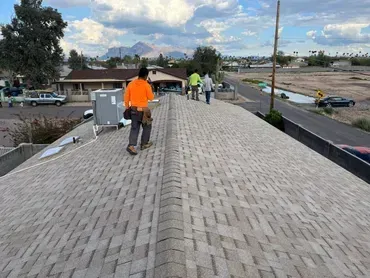 A group of people are standing on top of a roof.